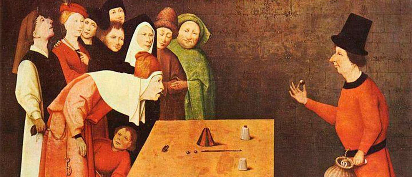 Ilusionista medieval realizando un Trucos de Magia para principiantes y magos profesionales ademas con copas frente a una audiencia