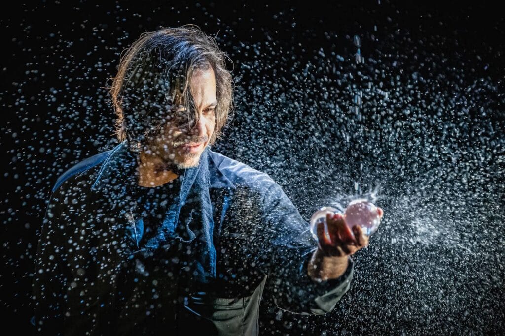 Mago moderno realizando un truco con agua, creando un efecto visual impresionante presentes en cada Trucos de Magia para principiantes y magos profesionales.