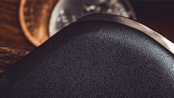 Detalle de la textura del monedero profesional de magia con monedas de fondo.