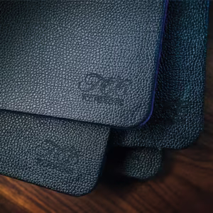 Tapetes rígidos grandes TCC apilados con textura de cuero negro grabado.