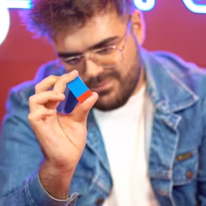 Magia visual con Ambitious Brick, un bloque Lego azul y rojo presentado por un mago en primer plano