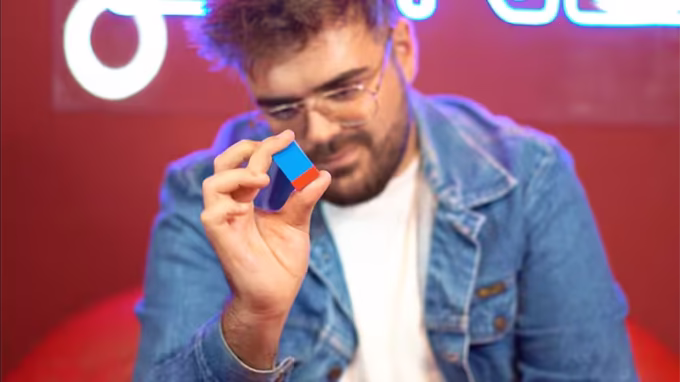 Magia visual con Ambitious Brick, un bloque Lego azul y rojo presentado por un mago en primer plano