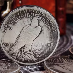 Reverso de la réplica Dólar de la Paz de 1921 mostrando un águila con detalles realistas, junto a otras monedas y un cofre vintage.