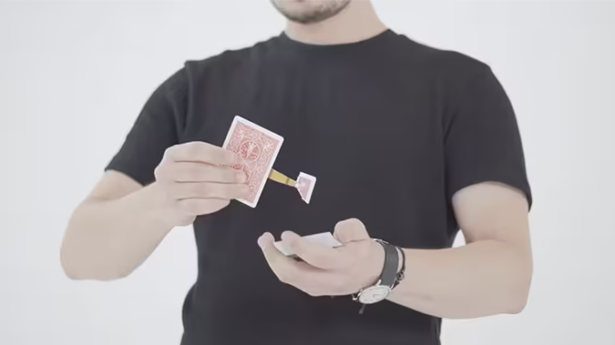 Mago realizando el efecto Little Thief con una carta roja