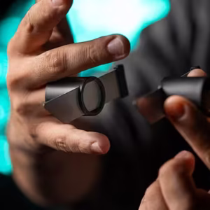 Manos realizando la ilusión mágica Stitch de Titanas, mostrando un objeto dividido en dos partes.