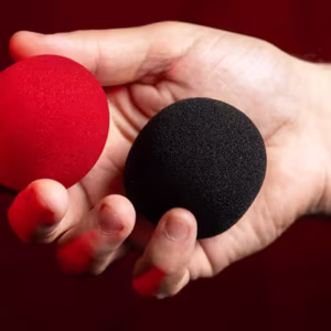 Bolas de Esponjas que Cambian de Color (rojo y negro) de Murphy's Magic sostenidas en la mano.