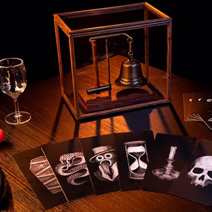 Spirit Bell Deluxe Set by Tony Anverdi con Spirit Cabinet, campana y martillo, copa de vidrio, bola roja y cartas ilustradas sobre mesa oscura